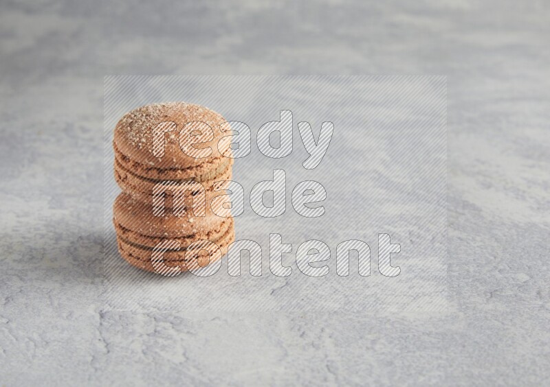 45º Shot of two Brown Hazelnuts macarons  on white  marble background