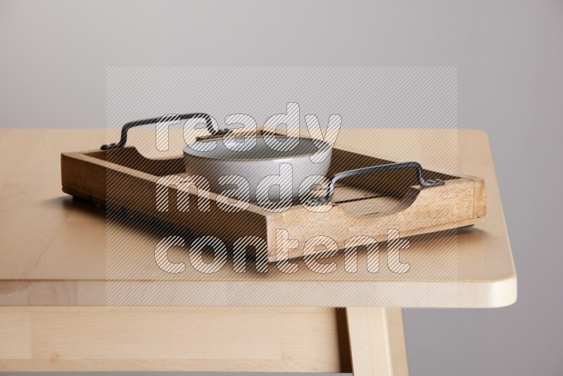 off white bowl on a light colored rectangular wooden tray with handles