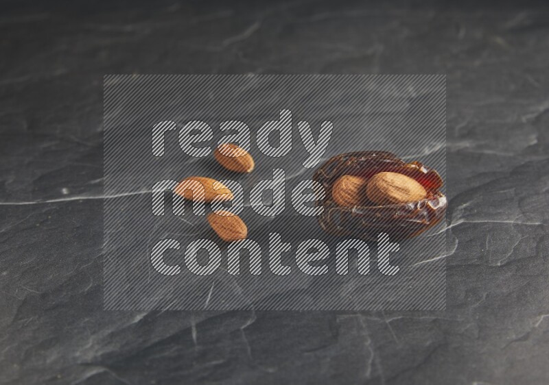almond stuffed madjoul date on a black textured background