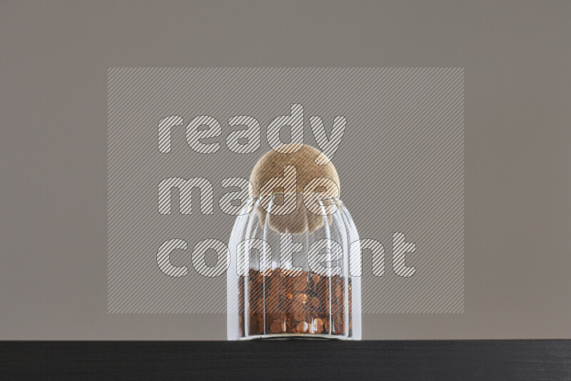 Sequins in a glass jar on black background
