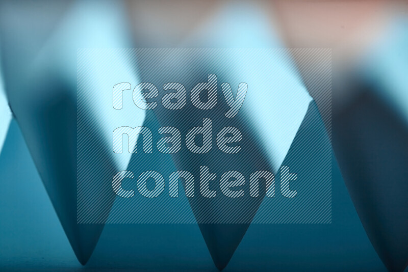 A close-up abstract image showing sharp geometric paper folds in blue gradients