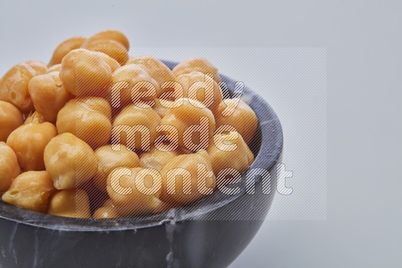 Close up shot of boiled chickpeas in a container on white background