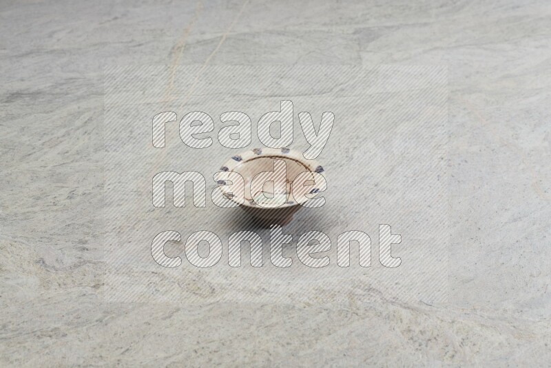 A decorative pottery plate on grey marble background