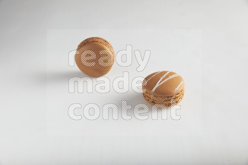45º Shot of of two assorted Brown Irish Cream, and Brown Coffee macarons  on white background