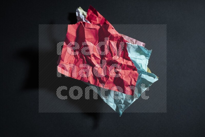 Crumpled multicolored paper on black background