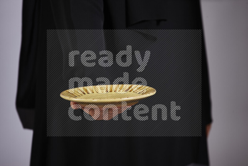 امرأة ترتدي عباءة سوداء تحمل أدوات فخارية مختلفة في أوضاع متعددة