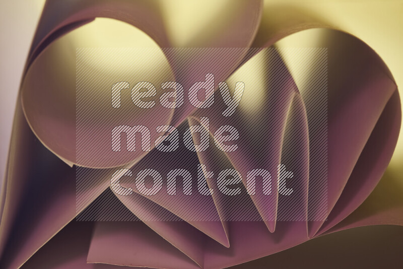 عرض فني لطيات الورق تخلق مزيج من الأشكال الهندسية، مضاءة بإضاءة ناعمة بدرجات اللون الودري والالوان الدافئة