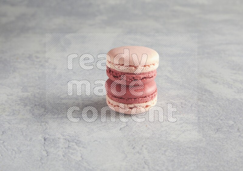 45º Shot of two Pink Litchi Raspberry macarons  on white  marble background
