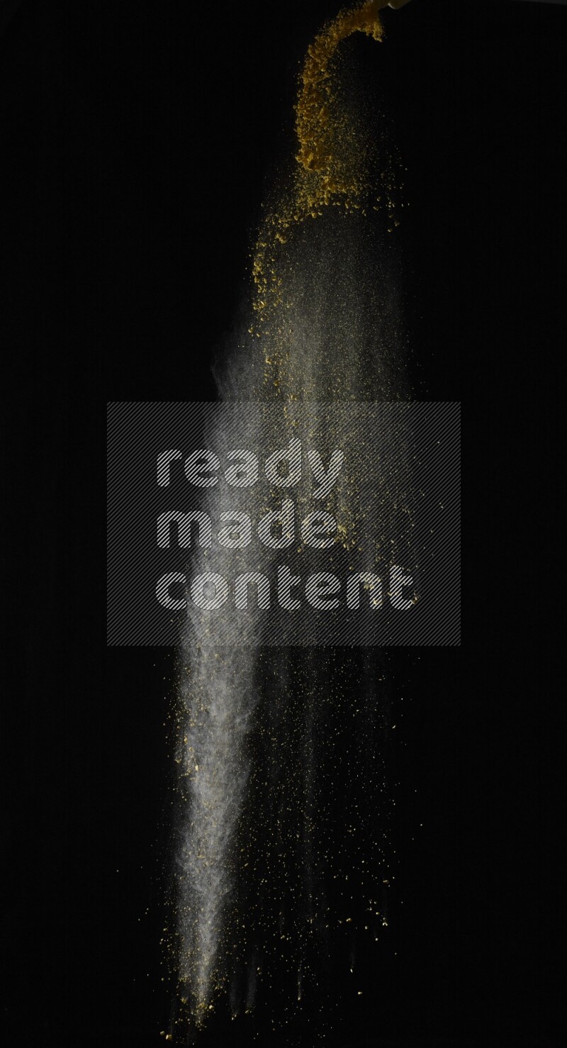 A side view of yellow powder explosion on black background