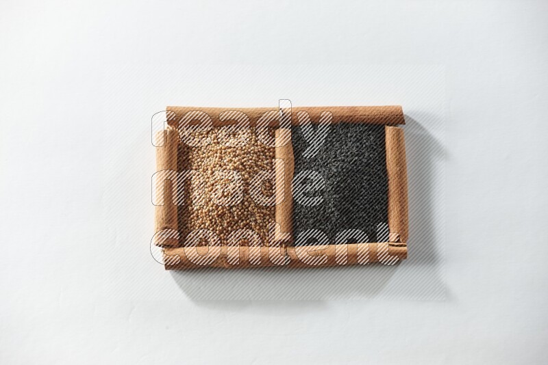 2 squares of cinnamon sticks full of mustard seeds and black seeds on white flooring