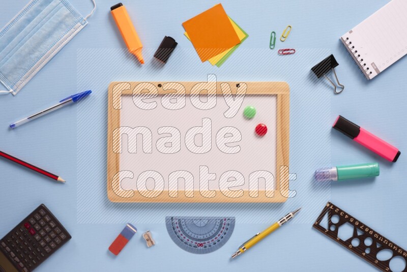 A whiteboard with assorted school supplies on blue background