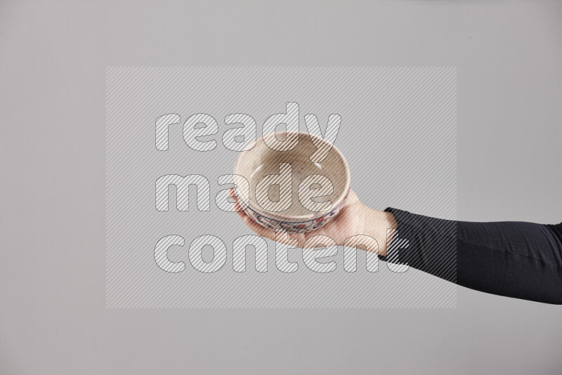 A woman in black abaya holding different pottery essentials in different positions