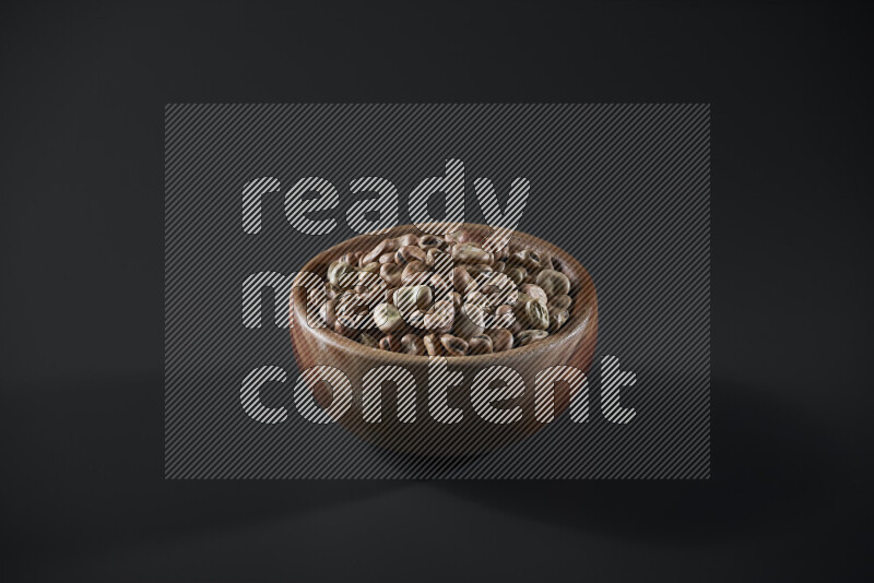 Fava beans in a wooden bowl on grey background