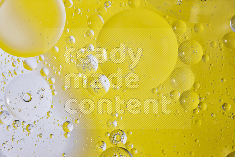 لقطات مقربة لفقاعات من الزيت على سطح الماء باللون الأبيض والأصفر