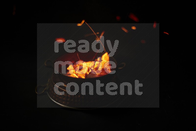 Coal cubes on fire in metal pan