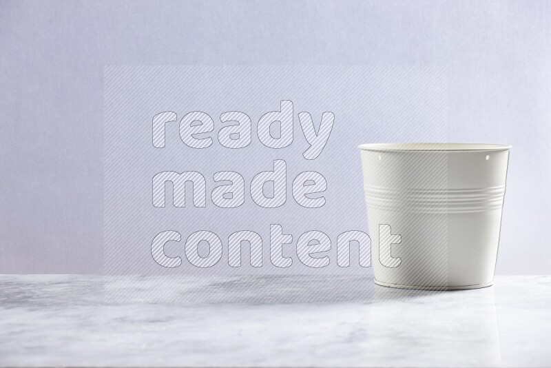 An empty white plant pot on grey marble background