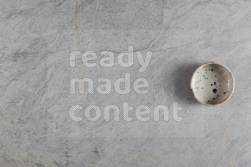 وعاء فخاري متعدد الألوان على خلفية من الرخام الرمادي