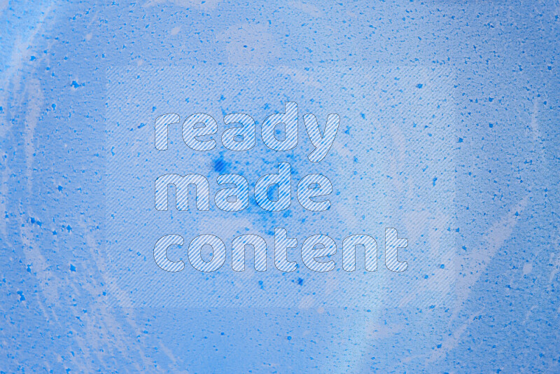 تلتقط الصورة تناثرا للطلاء الأزرق علي خلفية زرقاء