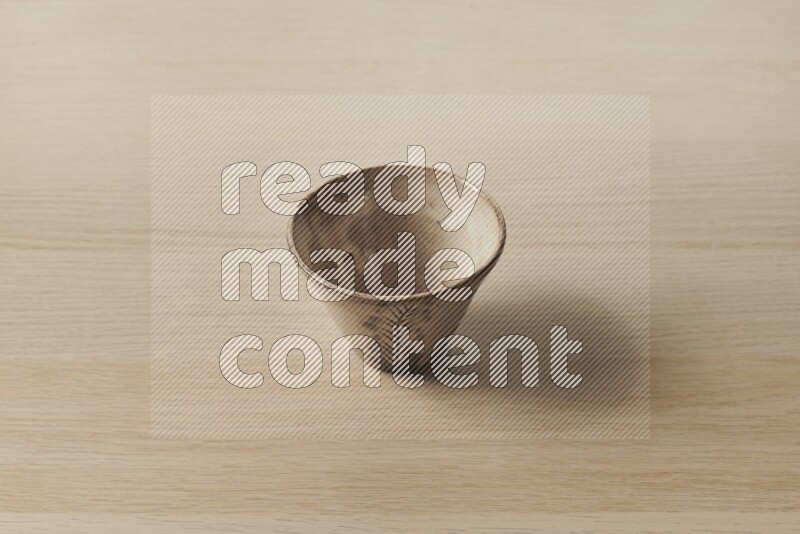 A decorative pottery bowl on light wooden background