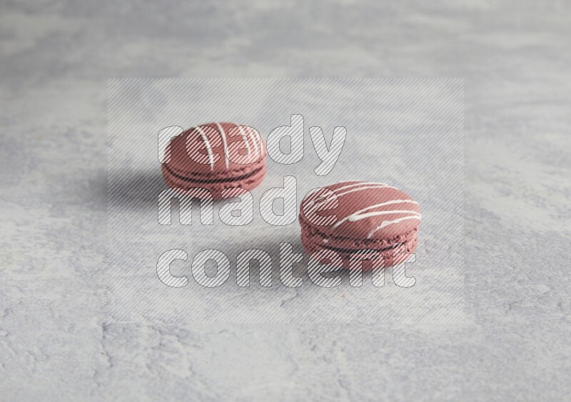 45º Shot of two Red Poppy Flower macarons on white  marble background