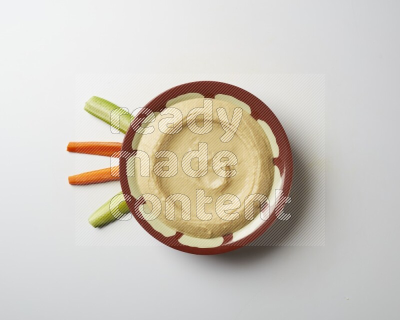 Plain hummus in a traditional plate on a white background