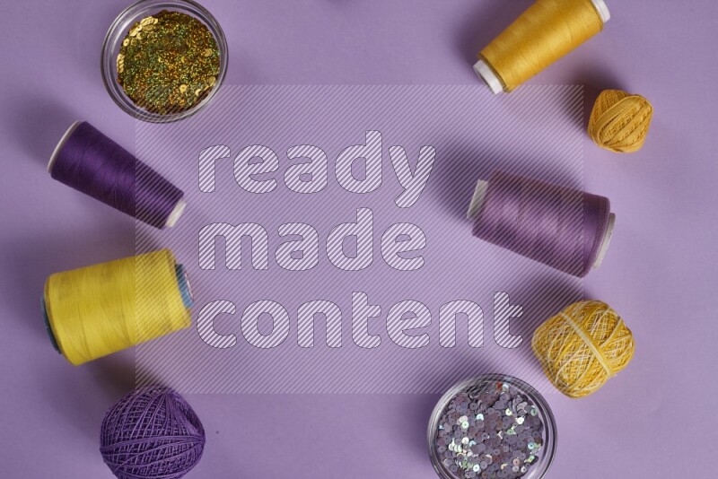 مجموعة من أدوات الخياطة والتفصيل صفراء وأرجوانية اللون على خلفية أرجوانية