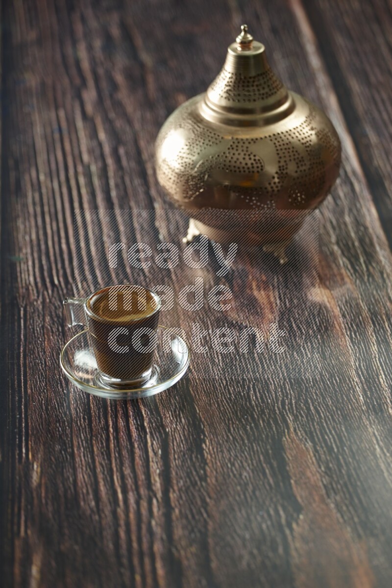 A golden lantern with different drinks, dates, nuts, prayer beads and quran on brown wooden background