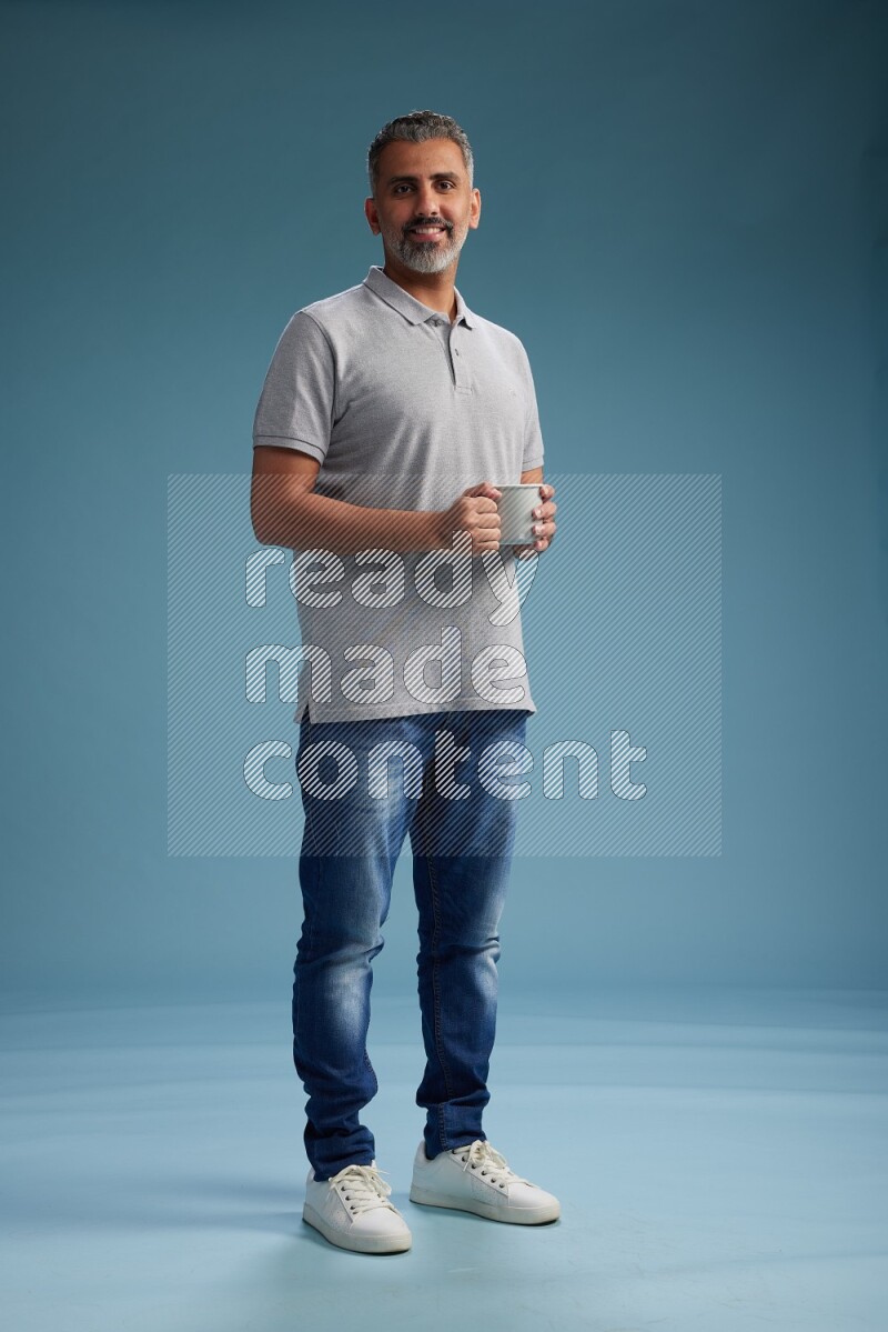 Man Standing drinking coffee on blue background