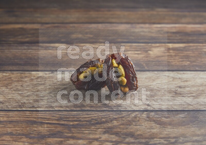 two pistachio stuffed madjoul date on a wooden background