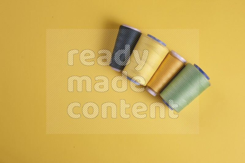 A green collection of sewing and tailoring tools arranged on a yellow background