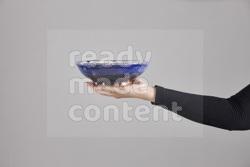 امرأة ترتدي عباءة سوداء تحمل أدوات فخارية مختلفة في أوضاع متعددة