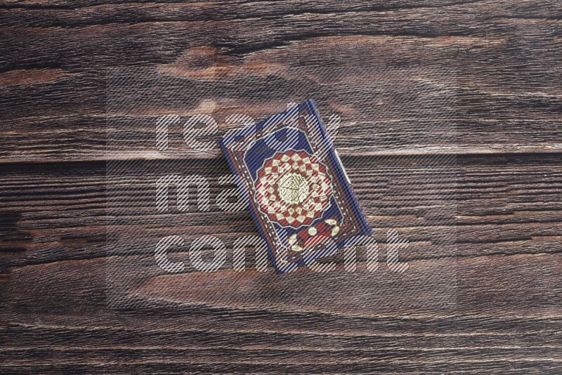 Quran with a prayer beads on wooden background