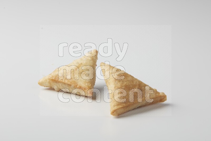 Two fried sambosas on a white background