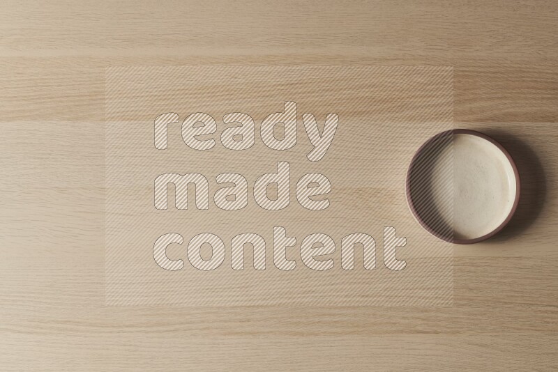 وعاء فرن فخاري باللون البيج على خلفية خشبية فاتحة