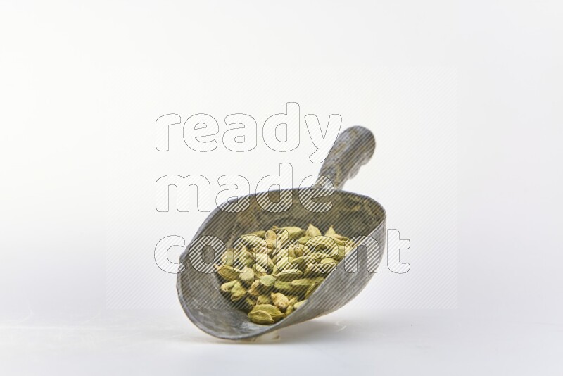 Cardamon in a shovel on white background