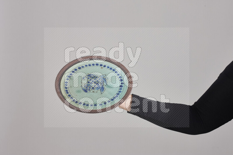 امرأة ترتدي عباءة سوداء تحمل أدوات فخارية مختلفة في أوضاع متعددة