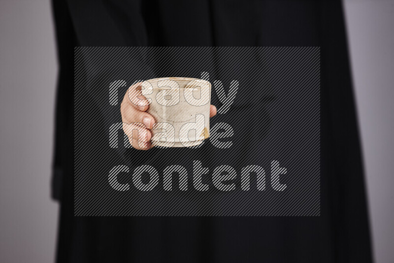 امرأة ترتدي عباءة سوداء تحمل أدوات فخارية مختلفة في أوضاع متعددة