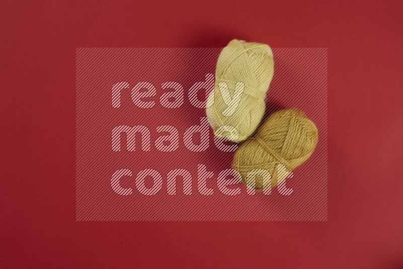 A yellow collection of sewing and tailoring tools arranged on a red background