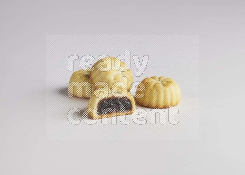 Four Pieces of Maamoul filled with date one of them is cut direct on white background
