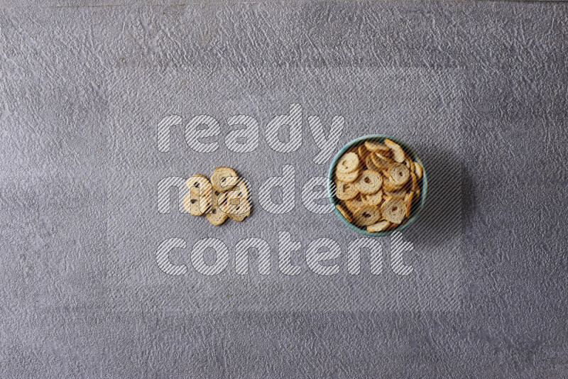 Assorted snacks in pottery bowls on grey background