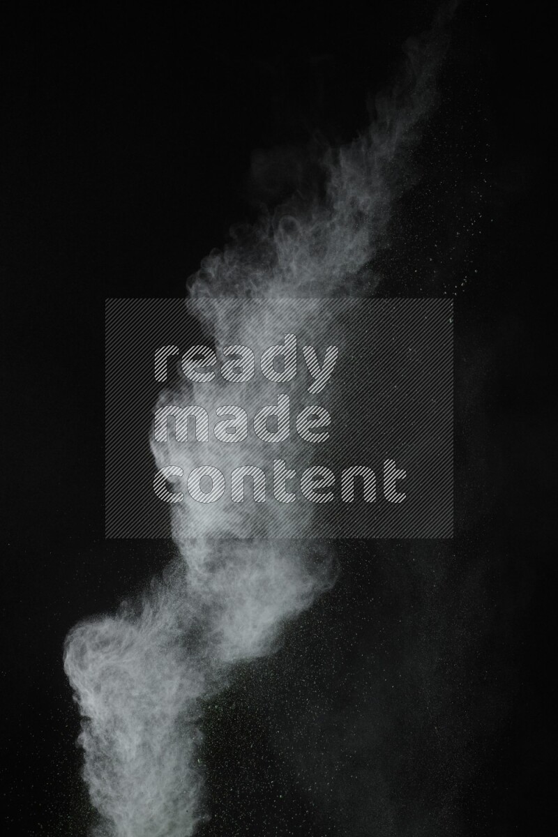 A side view of green powder explosion on black background