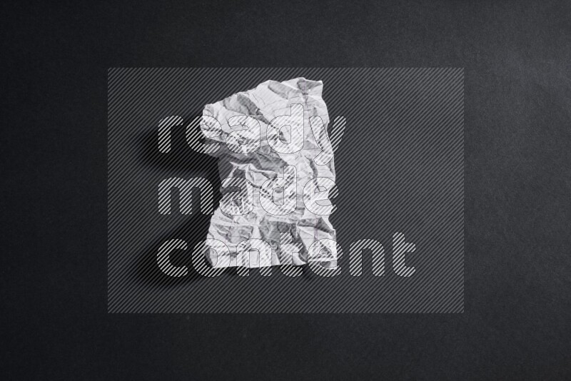 Crumpled notebook sheet on black background