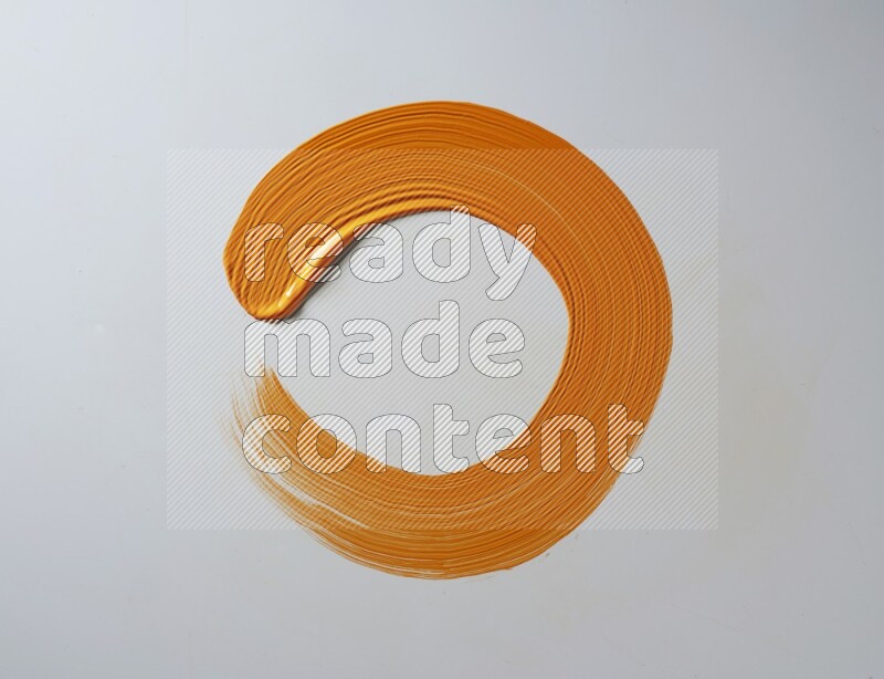 An orange circular painting brush stroke on white background