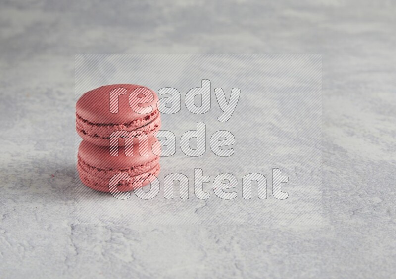 45º Shot of two Pink Raspberry macarons  on white  marble background