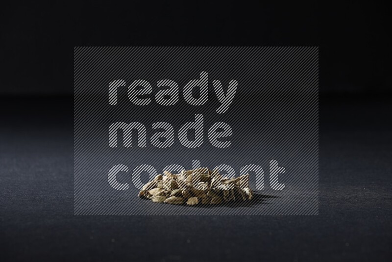 Cardamom in a circle shape on black flooring