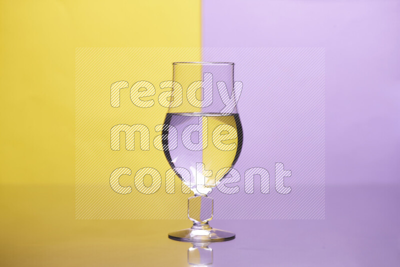 The image features a clear glassware filled with water, set against yellow and light purple background