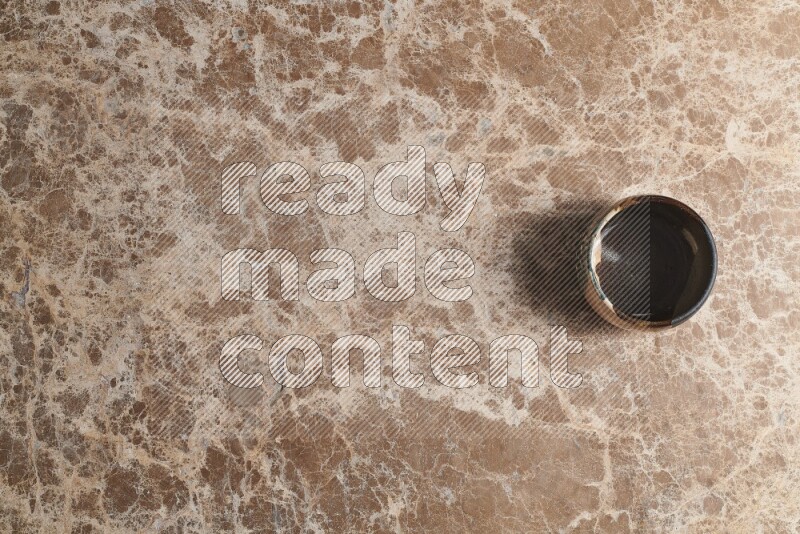 وعاء فخاري متعدد الألوان على خلفية من الرخام البيج