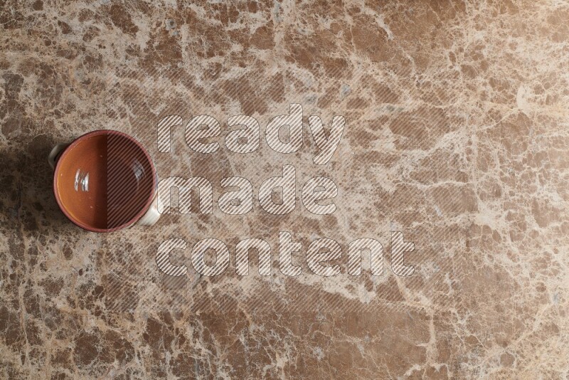 A multicolored pottery pot on beige marble background