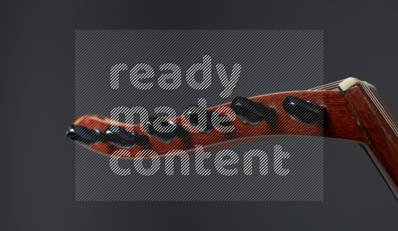 parts of a brown wooden Oud in a gray background