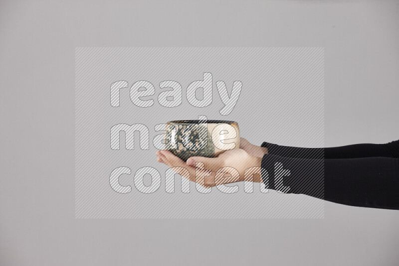 امرأة ترتدي عباءة سوداء تحمل أدوات فخارية مختلفة في أوضاع متعددة